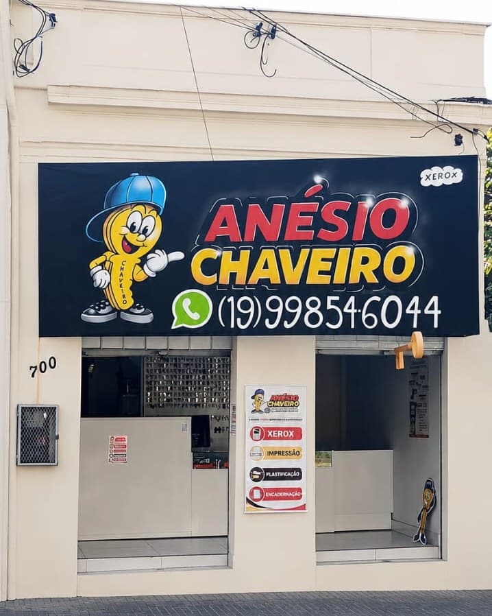 Fachada da loja na Rua Boa Morte, 700: letreiro azul com o mascote, Anésio Chaveiro e o WhatsApp, portas abertas para o balcão